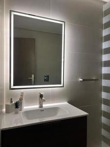 a bathroom with a sink and a large mirror at 101 - Comfy Space - 80TV smart - Self Check-in in Riyadh