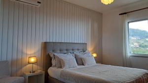 une chambre avec un lit avec deux lampes et une fenêtre dans l'établissement Typical Madeira Orchid House, à Calheta