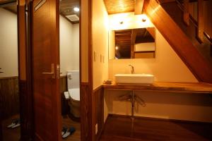 a bathroom with a sink and a toilet and a mirror at guesthouse絲 -ito-ゲストハウスイト in Fukumitsu +14 photos
