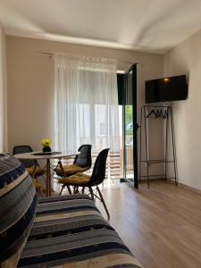 een woonkamer met stoelen en een tafel en een televisie bij Villa Promajna 5 in Promajna