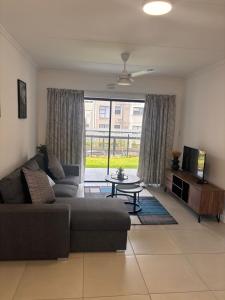 a living room with a couch and a table and a tv at Ballito Village 446 in Ballito