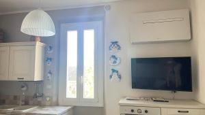 a living room with a tv and a window at Casa Lenzona in Certaldo +25 photos
