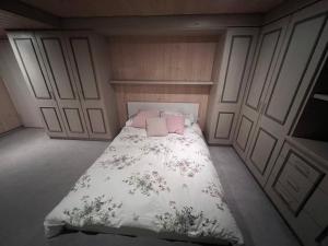 a small bedroom with a bed with a floral blanket at Habitación de Ana in Munich