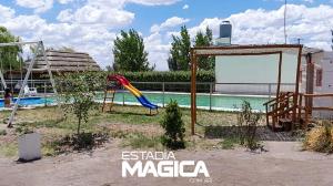 a playground with a slide next to a pool at Cabañas La Sagrada Familia in El Nihuil