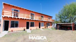 an orange house with a balcony on top of it at Cabañas La Sagrada Familia in El Nihuil