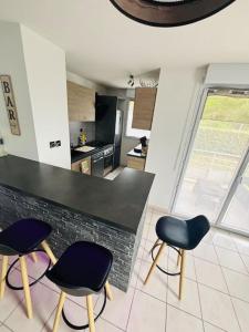 een keuken met 2 stoelen en een aanrecht met een aanrecht bij Appartement in Millau +3 foto's
