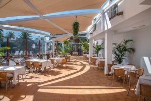 a restaurant with tables and chairs on a patio at Las Marismas de Corralejo in Corralejo
