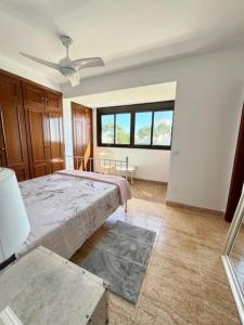 a bedroom with a large bed and a window at Estupendo Adosado La Cala de Mijas in La Cala de Mijas