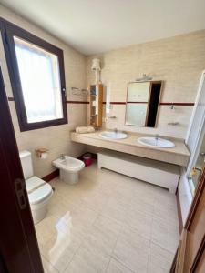a bathroom with two sinks and a toilet and a window at Estupendo Adosado La Cala de Mijas in La Cala de Mijas