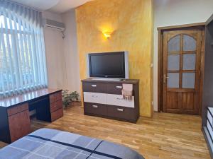 a room with a tv on a dresser and a room with a door at Panoramic Apartment in Târgu-Mureş