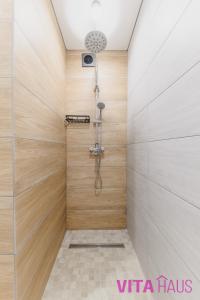 a bathroom with a shower with wooden walls at Фирменные апартаменты от Vita Haus Beverly in Petropavlovsk