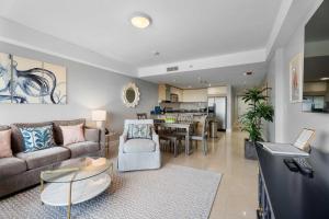 Una sala de estar con un sofá y un comedor. en Beachfront - Amazing View 2BR condo - A342, en Palm-Eagle Beach