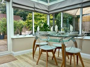 a dining room with a glass table and chairs at Leaze Garden Cottage - Frome in Frome