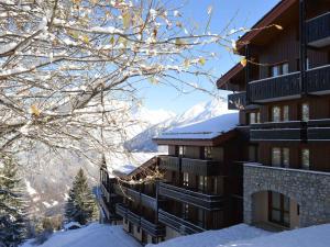 a building in the snow with a mountain in the background at Appartement rénové proche des pistes - 4 pers, balcon, casier à skis - FR-1-575-211 in Courchevel +9 photos