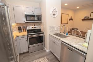 a kitchen with white cabinets and a stainless steel refrigerator at LB207A Newly Renovated Family Friendly Washer Dryer Fireplace WiFi EZ Parking in Snowshoe
