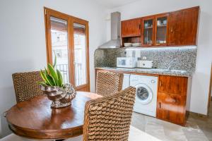 a kitchen with a table and a washing machine at Apartamentos El Tranco del Mar in Almuñécar