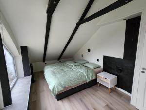 a bedroom with a bed and a night stand in a attic at Senja Skaland in Melkarhola
