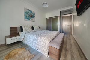 a bedroom with a large bed and a tv at La Siesta Beach Resort in Mohammedia