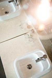 a bathroom sink with two glasses and a faucet at Hotel Daniel Vienna - Smart Lifestyle Near City Centre in Vienna