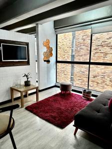 a living room with a couch and a red rug at Apartamento en Chapinero in Bogotá