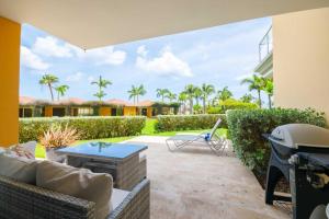 a patio with a couch and a table at Beachfront - Garden Delight 3BR condo - E125 in Palm-Eagle Beach