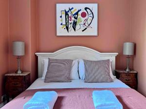 a bedroom with a white bed with two pillows at Spacious Georgian Apartment - Central Frome in Frome