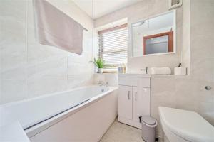 a white bathroom with a tub and a sink at Apple Cottage - Central Frome - Outdoor Space in Frome +19 photos