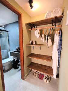 a bathroom with a rack of clothes and shoes at Loft do Fotógrafo 4 - Poucos passos do Rio das Almas in Pirenópolis