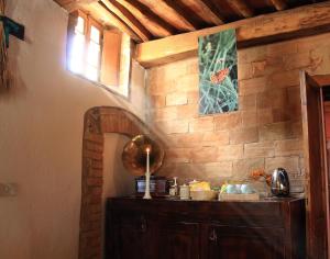 una camera con una parete in pietra e un armadio in legno di La Locanda del Loggiato a Bagno Vignoni