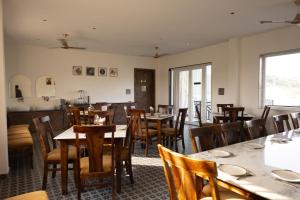 a dining room with wooden tables and chairs at Akaya Hills in Udaipur
