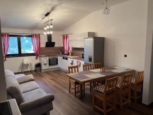 a kitchen and dining room with a table and chairs at Apartmán 27 Krkonoše - Ubytování v Krkonoších se saunou in Trutnov