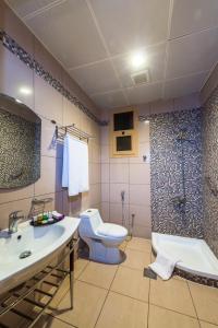a bathroom with a toilet and a sink and a shower at Boudl Al Fakhria in Unayzah