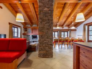 a living room with a red couch and a stone pillar at Chalet Casot Pra La Funt by Interhome in Sampeire +22 photos