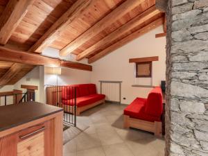 a living room with red furniture and a stone wall at Chalet Casot Pra La Funt by Interhome in Sampeire