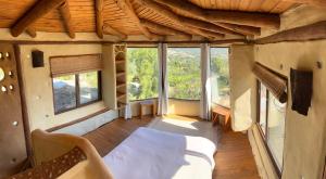 a room with a bed and some windows at Swiss Eco Lodge La Linda Loma - Olmué in Olmué