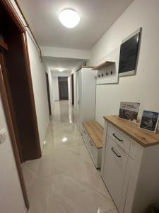 a kitchen with a white refrigerator and a hallway at Apartman Vidić 2 in Požega +3 photos