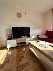 a living room with a large flat screen tv at Apartman Vidić 2 in Požega