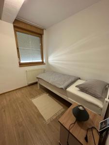 a small bedroom with a bed and a window at Apartman Vidić 2 in Požega