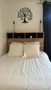 a bed with a tree sticker on the wall at Studio aux pieds des vignes in Eguisheim