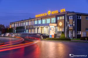 a hotel building with cars parked in front of it at Hotel & SPA Odeon in Boguchwała