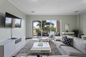 a living room with a couch and a tv at Eagle Beach - Serenity by the Sea 3BR condo -LV301 in Palm-Eagle Beach