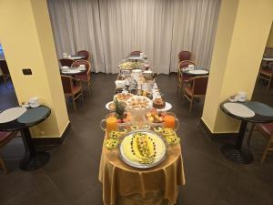 ein langer Tisch mit einem Buffet voller Speisen in der Unterkunft Mokinba Hotels Sant'Ambroeus in Mailand
