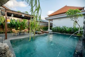 a swimming pool in front of a house at Sapta D'Villa Residence by Purely in Ubud