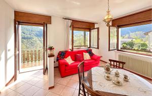 a living room with a red couch and a table at Lovely Apartment In Lamon With Wifi in Lamon