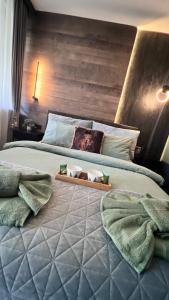 a bedroom with a large bed with a wooden headboard at Апартамент - Боровец Хотел ''Боровец Гардънс'' A 44 in Borovets