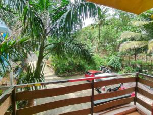 a balcony with a fence and a motorcycle in a forest at Kalapani Nest in Port Blair