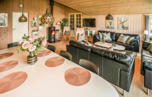 a living room with a table and a couch at Stunning Home In Væggerløse With Sauna in Marielyst