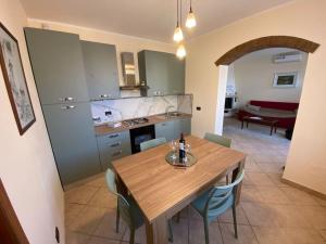 a kitchen and dining room with a wooden table and chairs at Dimora San Genesio in Casciana Terme