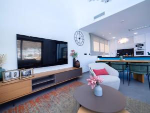 un salon avec une grande télévision à écran plat dans l'établissement Villa Villa Dorada by Interhome, à La Cala de Finestra