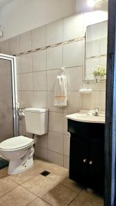 Un baño con inodoro, lavabo y espejo. en Olivia en Misiones, en Posadas